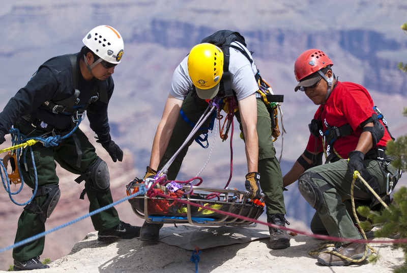 3 medics with stretcher in rescue training on mountain